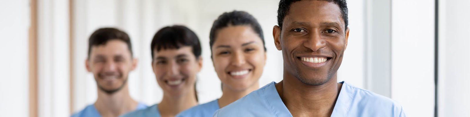 Four senior living nursing assistants smiling